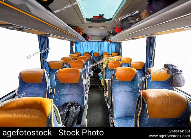 Bus interior empty seats, stop on a long distance trip, blanked out windows with copy space