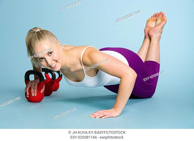 Fitness girl in chest press position with a kettlebell