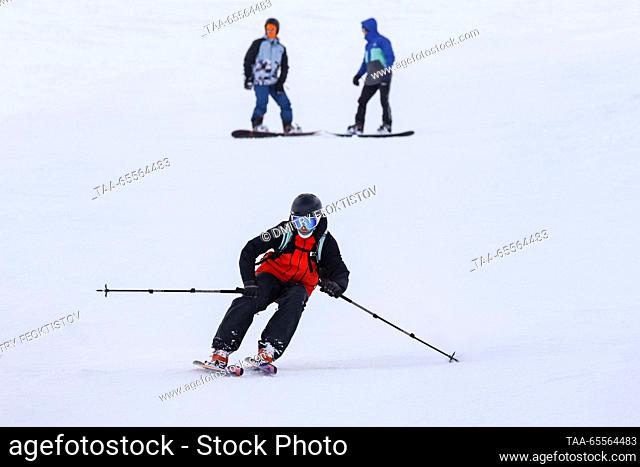 RUSSIA, SOCHI - DECEMBER 8, 2023: A skier and snowboarders are seen on a slope of the Rosa Khutor mountain resort. Dmitry Feoktistov/TASS
