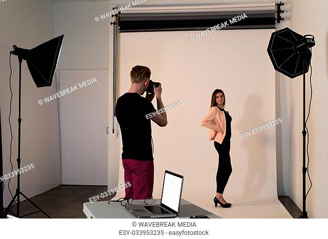 Rear view of man photographing female model