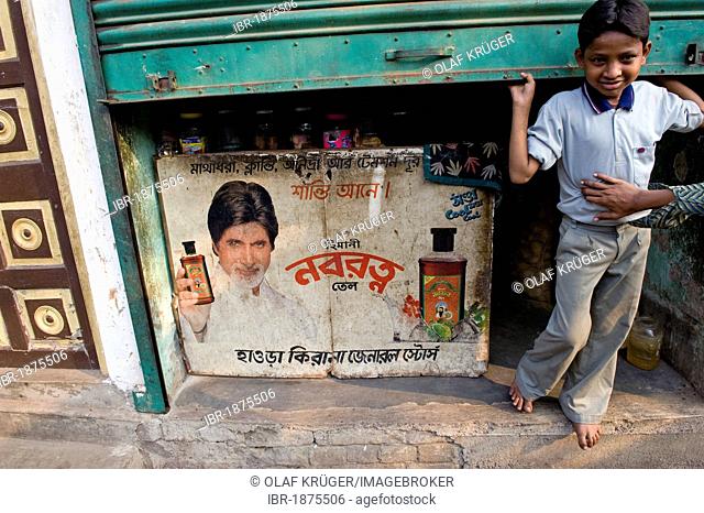 Boy standing next to a poster with the famous actor Amitabh Bachchan, Shibpur district, Howrah, Kolkata, West Bengal, India, Asia