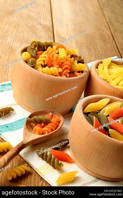 Raw tricolor pasta set on the wooden table