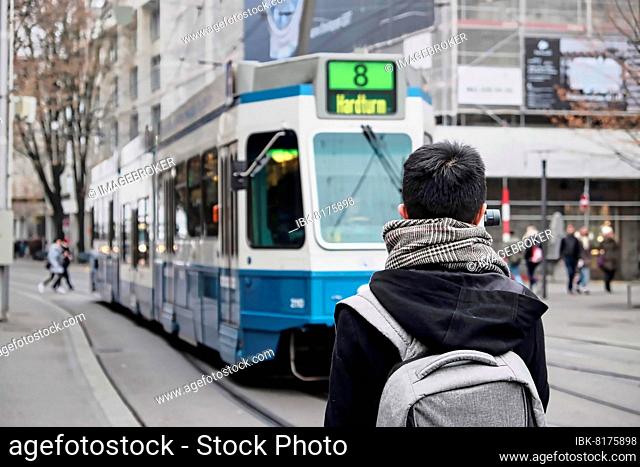 Man in front of a blue tram in Zurich, Switzerland, Europe