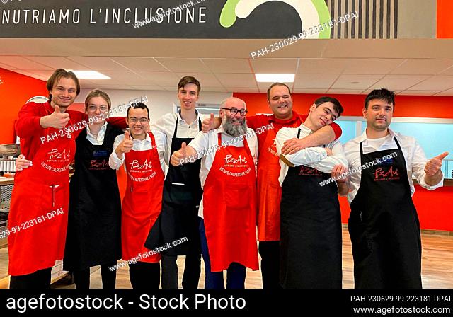PRODUCTION - 22 June 2023, Italy, Monza: Nico Acampora (M), founder of the project and restaurant, and his team of waiters and pizza makers from the restaurant...