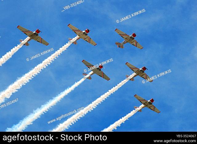 A team of skywriters for a delta formation against a blue sky