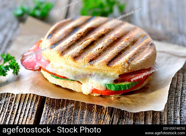 Getoastetes und im Kontaktgrill gepresstes italienisches Panini mit Schinken und Käse - Pressed and toasted double panini with ham and cheese served on sandwich...