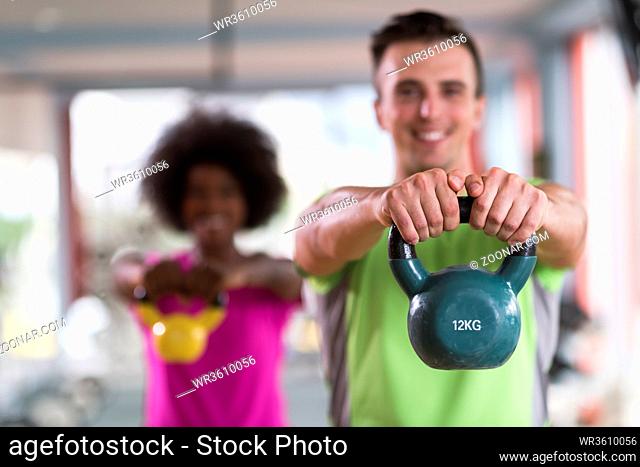 healthy couple workout with weights lifting dumbbels at crossfit gym african american woman with afro hairstyle