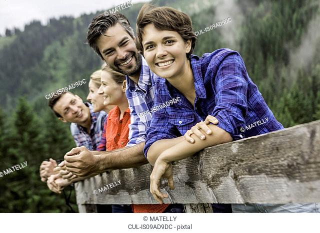 Group of friends leaning on wooden fence, Tirol, Austria