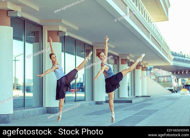 Two young beautiful twin sister dancing ballet in the city with ballet costume. urban sync dance. industrial street dancing. with special effect