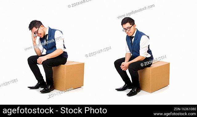 The young employee sitting on the box isolated on white