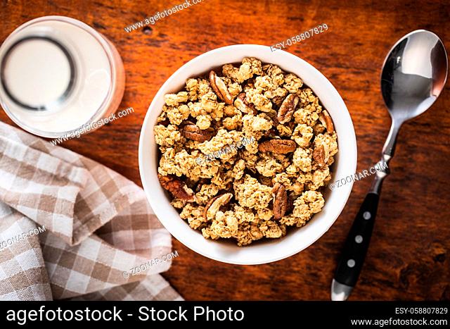 Breakfast cereal. Morning granola in bowl on wooden table. Top view
