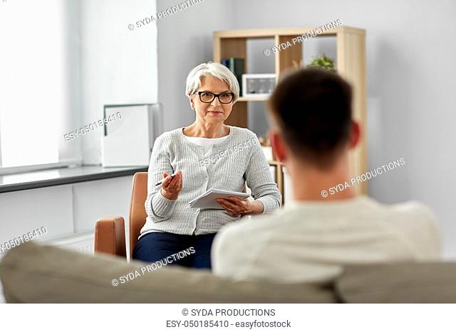 senior woman psychologist and young man patient