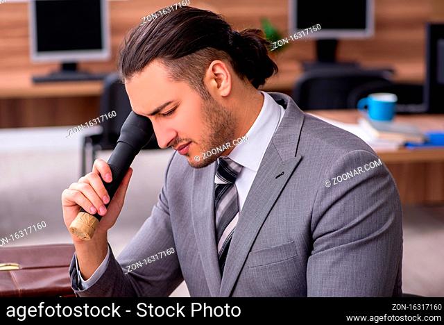 Young male employee working in the office environment