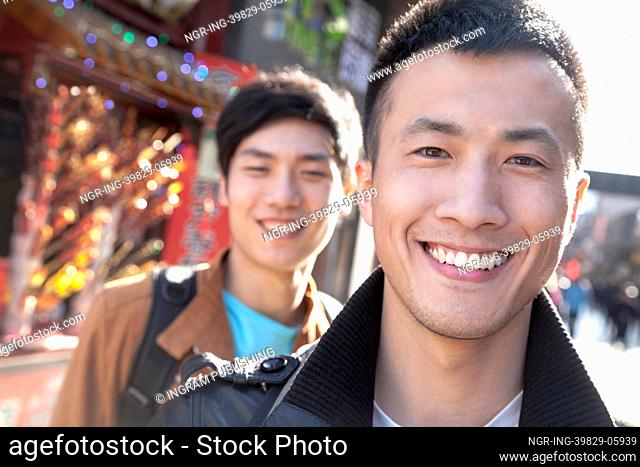 Two young men with Chinese Architecture in background