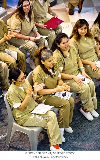 Wearing academic caps and gowns, three inmates are joined by their fellow multiracial prisoners in the city jail in Santa Ana, CA