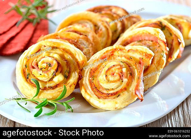 Luftiges Gebäck: Herzhafte Blätterteig-Schinkenschnecken mit Frischkäse und Parmesan sowie frischen Kräutern - Baked hearty puff pastry snacks with ham