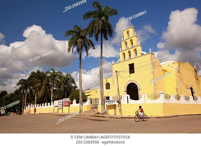 Cyclist in the street at the historic center with the Church of the Immaculate Conception at the background, Chumayel, Yucatan Province, Mexico, Central America