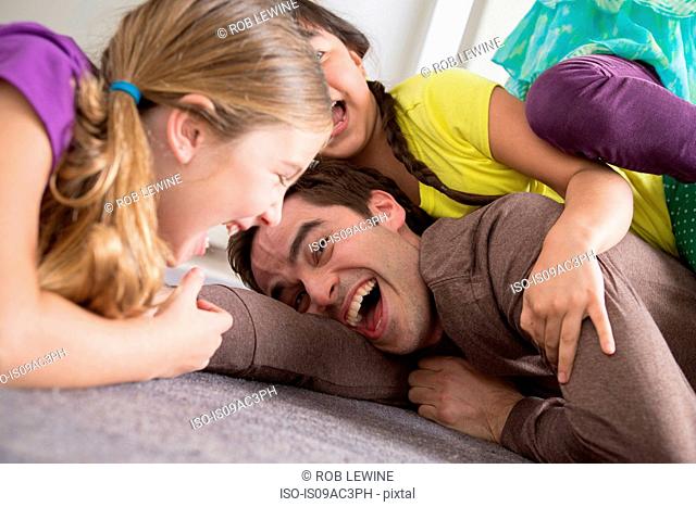 Girls tickling father