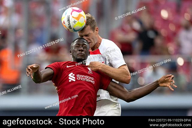 21 July 2022, Saxony, Leipzig: Soccer: Test matches, RB Leipzig - FC Liverpool at the Red Bull Arena. Leipzig's Alexander Sörloth (r) heads the ball away from...