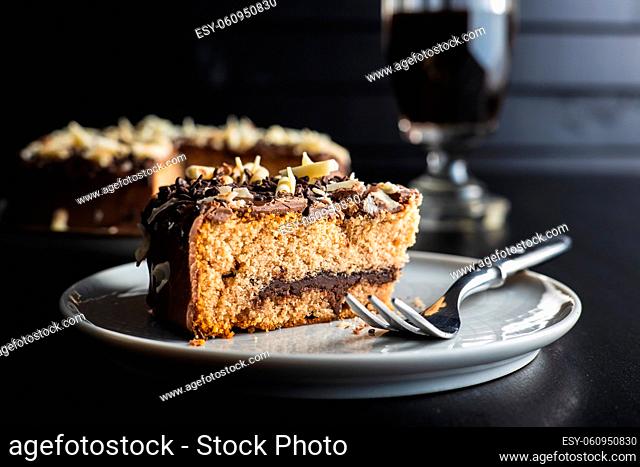 Sweet chocolate pie. Cake with chocolate sprinkles on black table