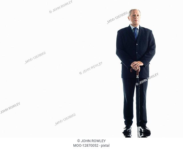 Middle-aged businessman leaning on umbrella