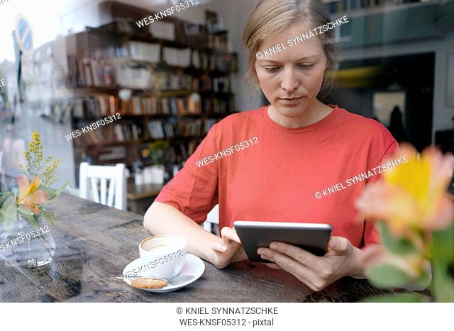 Young woman using tablet at the window in a cafe