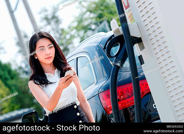 Young women use a mobile phone charging car buffet