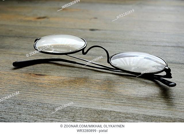 pair of vintage spectacles on wooden background