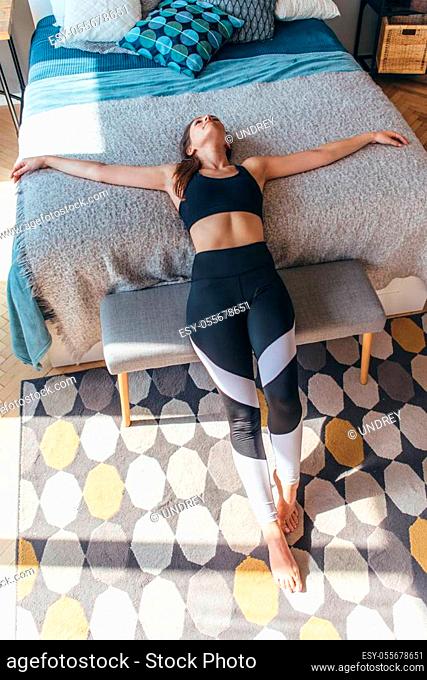 Fitness woman athlete lying on the bed and resting