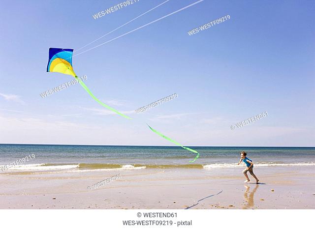 Germany, Baltic sea, Boy 8-9 flying kite at beach