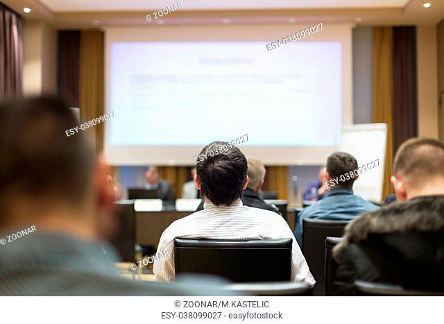Audience in lecture hall participating at business conference