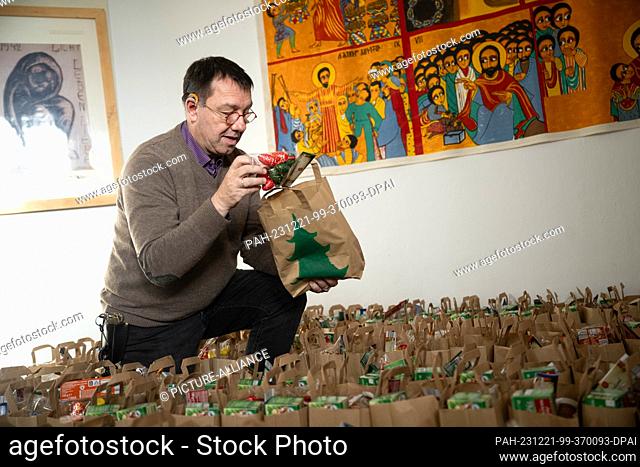 PRODUCTION - 20 December 2023, Bremen: Pastor Christian Fische distributes Christmas bags in the Bremen-Oslebshausen correctional facility (JVA)