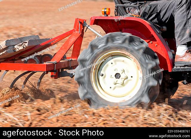 Red Tractor With Plough Plowing Field Soil Close Up View