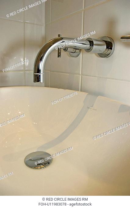 Close-up of chrome tap and cream basin