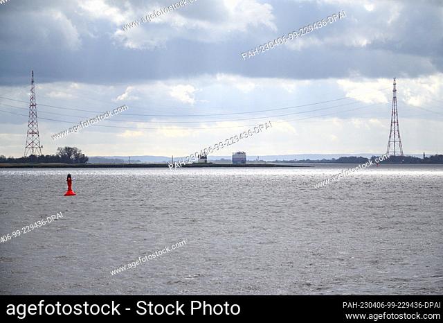 24 March 2023, Lower Saxony, Bützfleth: A container ship sails on the Elbe under the power pylons of the Elbe crossing. Photo: Jonas Walzberg/dpa
