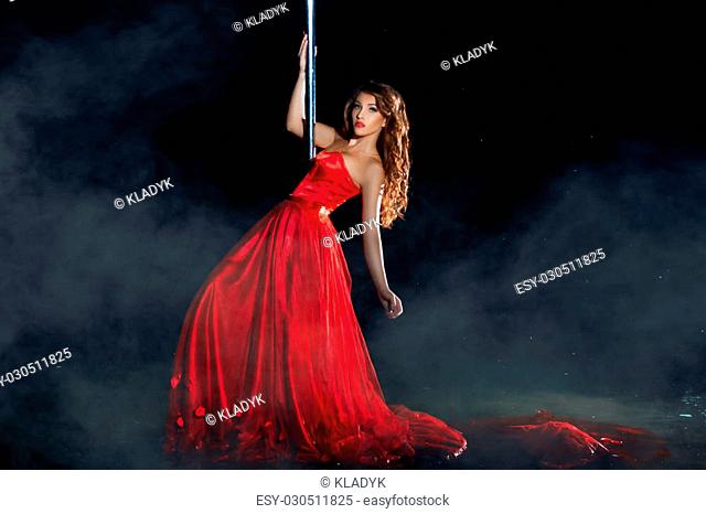 Girl in the red dress dances around a pole dancing night mist. See more images from this series