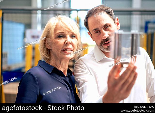 Businessman with senior businesswoman analyzing heating module in industry