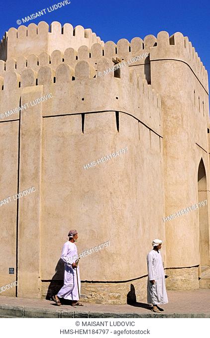 Oman, Nizwa, Omani man in front of the 17th century Fort