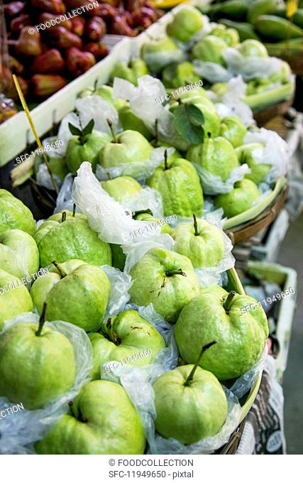 Fresh guavas wrapped in foil at a market in Thailand