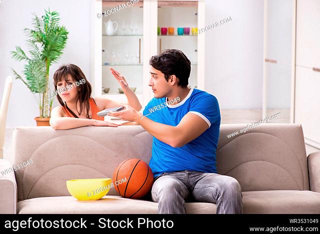 Man watching basketball with his wife