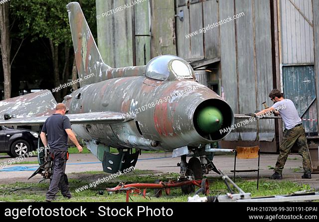 06 July 2021, Mecklenburg-Western Pomerania, Ribnitz-Damgarten: In the Technik-Museum Pütnitz club members work on a former Russian fighter aircraft of the type...