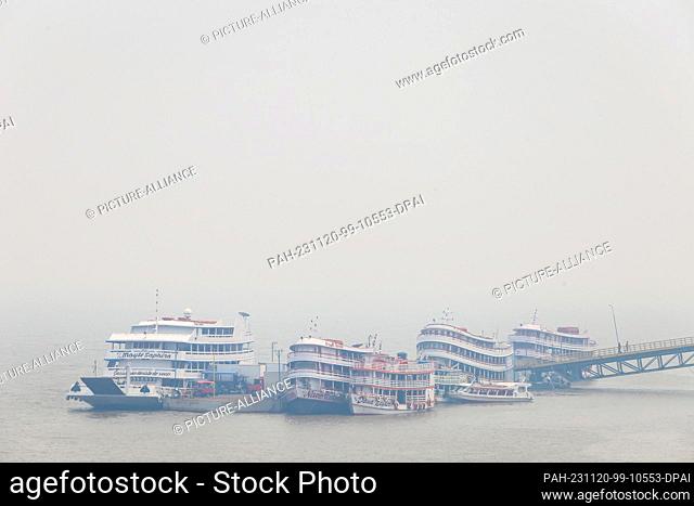 PRODUCTION - 02 November 2023, Brazil, Parintins: Boats and ships are covered in smoke during a forest fire at the harbor