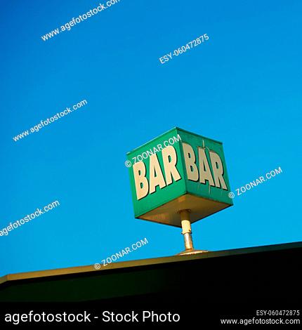 Bar sign on the roof against the blue sky. Space for your own text