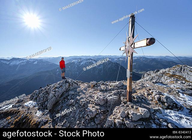 Mountaineer at the summit of the Guffertspitze, summit with summit cross, sun star, in autumn, Brandenberg Alps, Tyrol, Austria, Europe