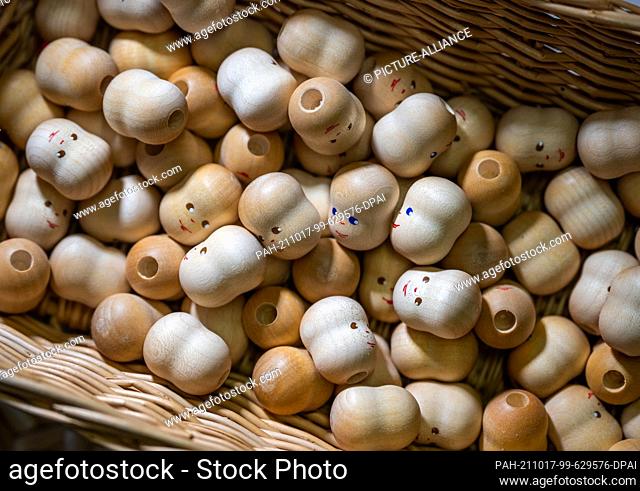 16 October 2021, Saxony, Grünhainichen: Turned and painted doll heads lie ready in the workshop of toymaker Annedore Krebs to make wooden jointed dolls