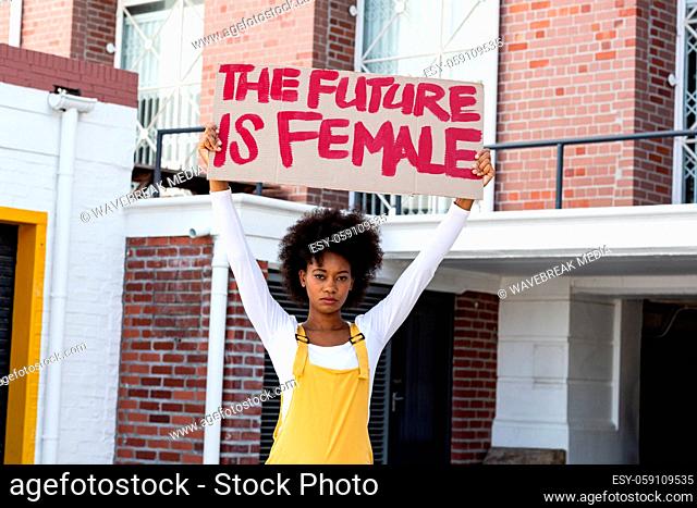 Portrait of mixed race woman holding placard