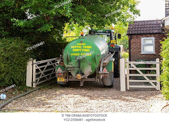A septic tank being emptied in the Uk using a tractor and trailor