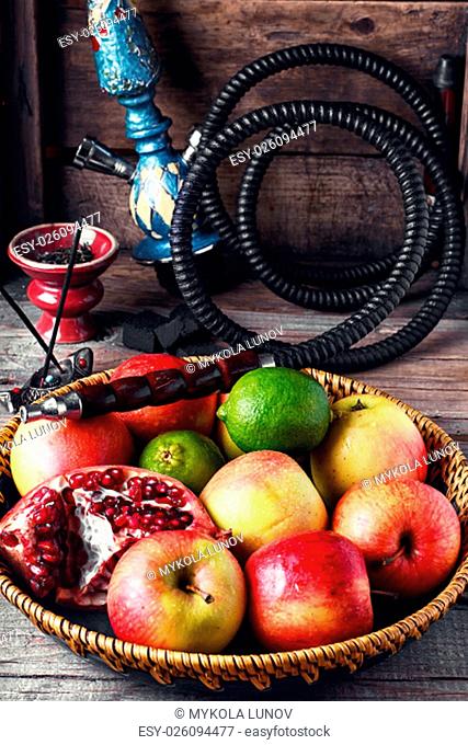 Stylish Smoking hookah and basket with apples, pomegranate and lime