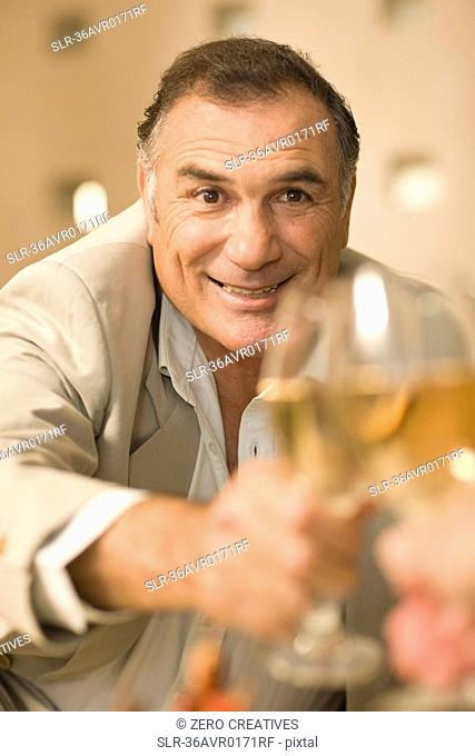 Businessman toasting with glass of wine