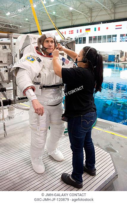 NASA astronaut Tom Marshburn, Expedition 3435 flight engineer, dons a training version of the Extravehicular Mobility Unit (EMU) spacesuit in preparation for a...